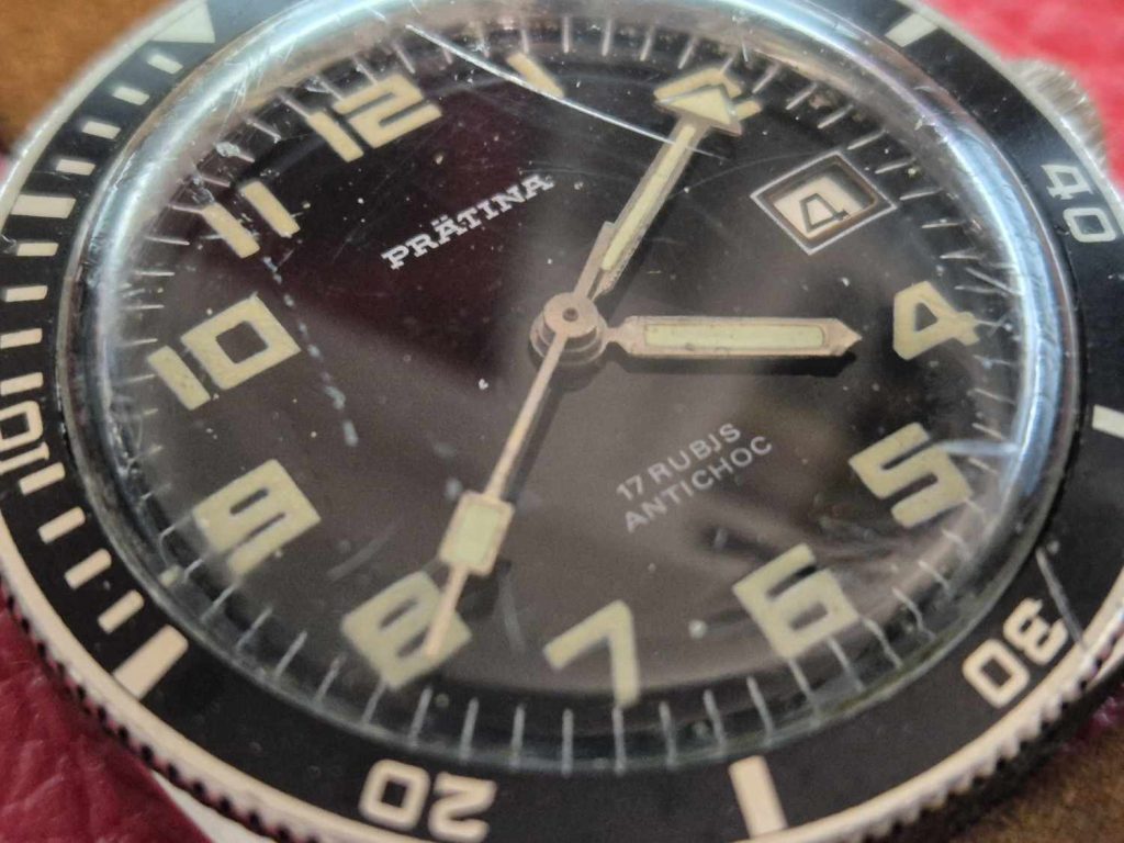 Detailansicht des Zifferblatts der Prätina Skin Diver mit arabischen Zahlen, Leuchtzeigern und 17 Rubis Antichoc-Schriftzug.