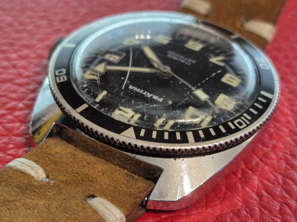 Schräg von oben fotografierte Prätina Skin Diver mit gut sichtbarer Patina, verkratztem Glas und kräftigen Ziffern.